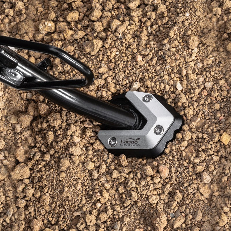 Cavalletto laterale della BMW C 400 con la piastra CJC092 appoggiato su terra battuta