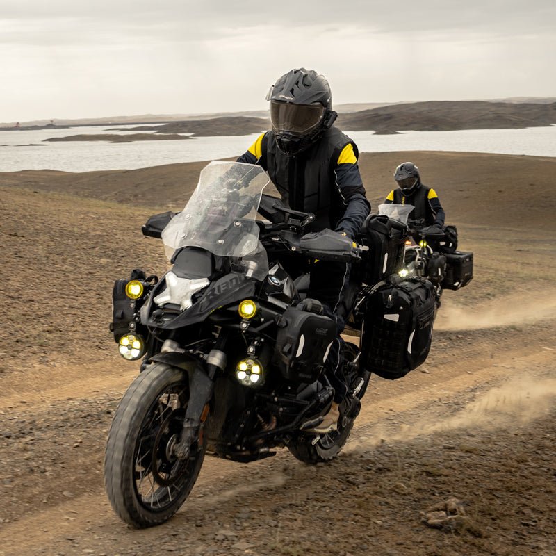 Due moto adventure equipaggiate con borse laterali LOBOO Alps su pista sterrata